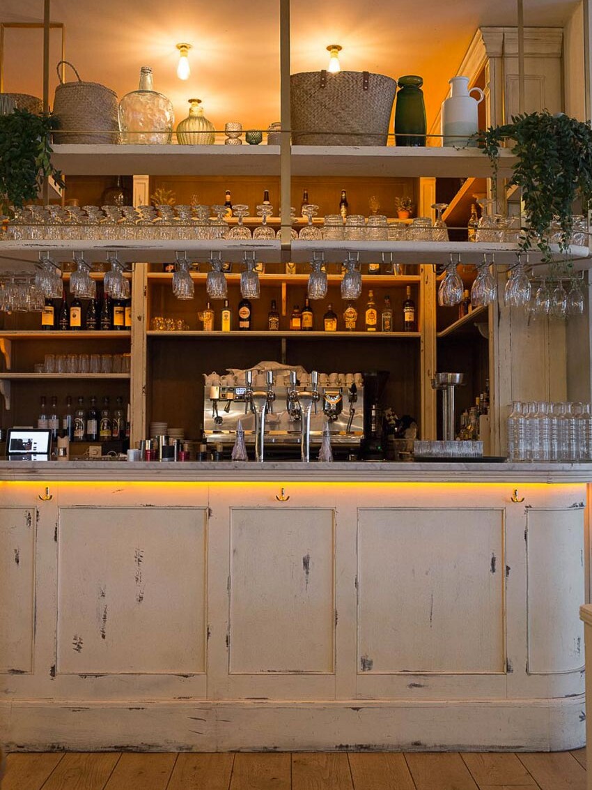 Intérieur du restaurant Simonetta de Paris. Comptoir en bois vieilli et parquet au sol. Décoration par le Studio Emma Roux