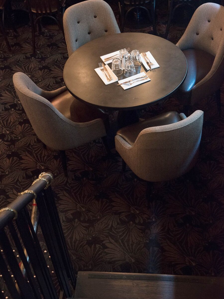 Intérieur du restaurant Le Morny de Paris, moquette au sol et fauteuils avec assises en cuir. Décoration par le Studio Emma Roux