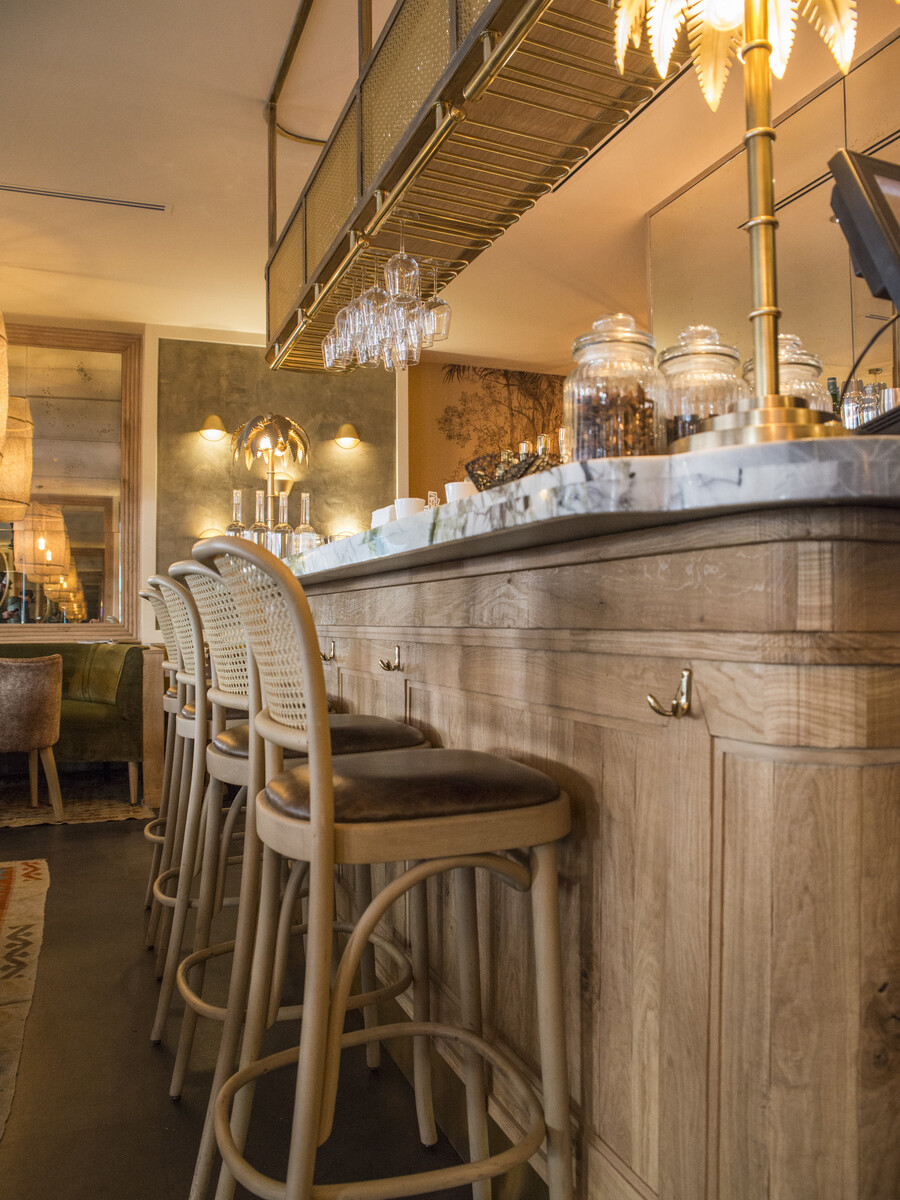 Restaurant Le Murillo de Paris - Décoration Emma Roux. Chaises en cannage, marbre, bois brut, luminaire en laiton.